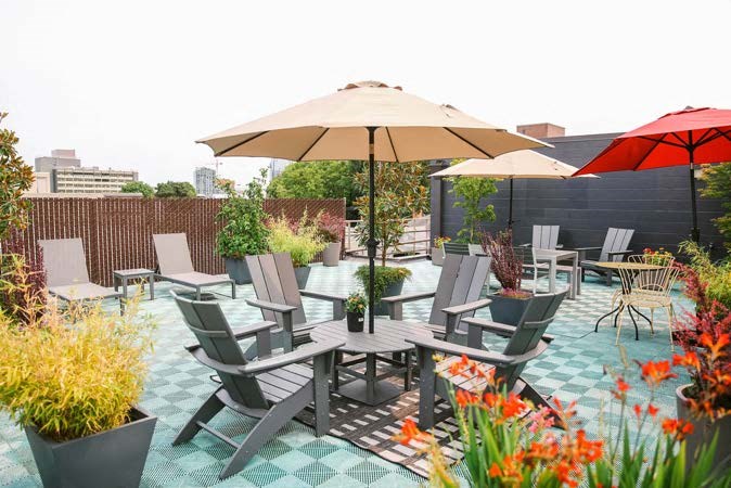 a patio with chairs and umbrellas on a roof
