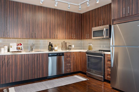 A modern kitchen with wooden cabinets and stainless steel appliances.