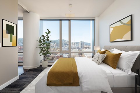 A bedroom with a large bed and a view of the city.