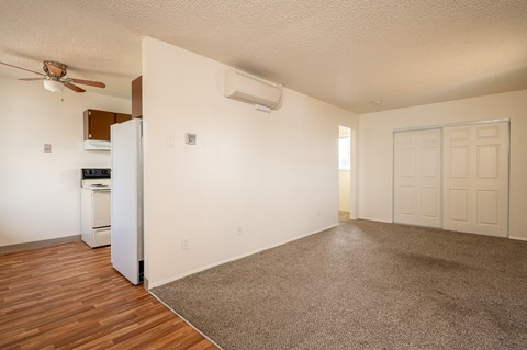 A room with a refrigerator and a ceiling fan.