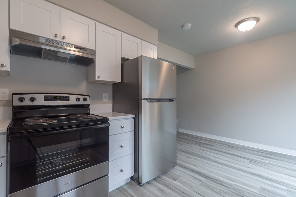 a kitchen with white cabinets and stainless steel appliances