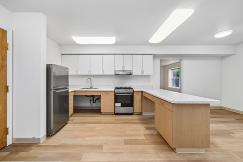 A kitchen with a refrigerator, oven, and sink.