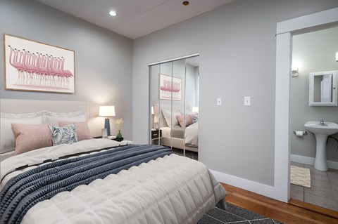 A bedroom with a large bed and a framed picture of a menorah on the wall.