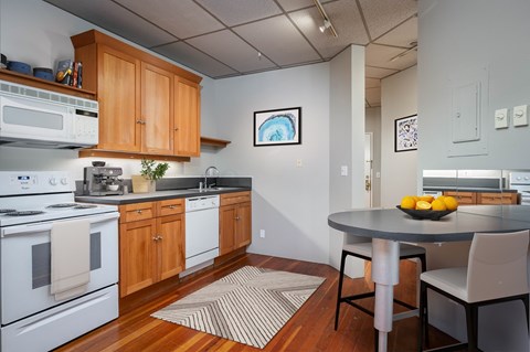 A kitchen with a table and chairs.
