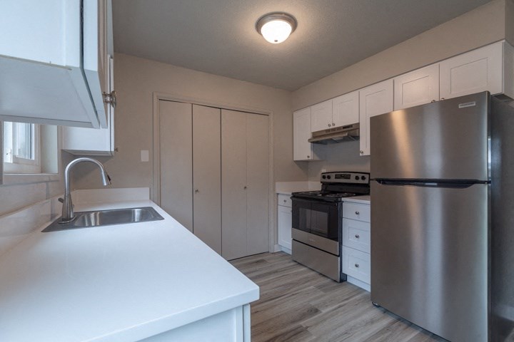 a kitchen with white cabinets and stainless steel appliances