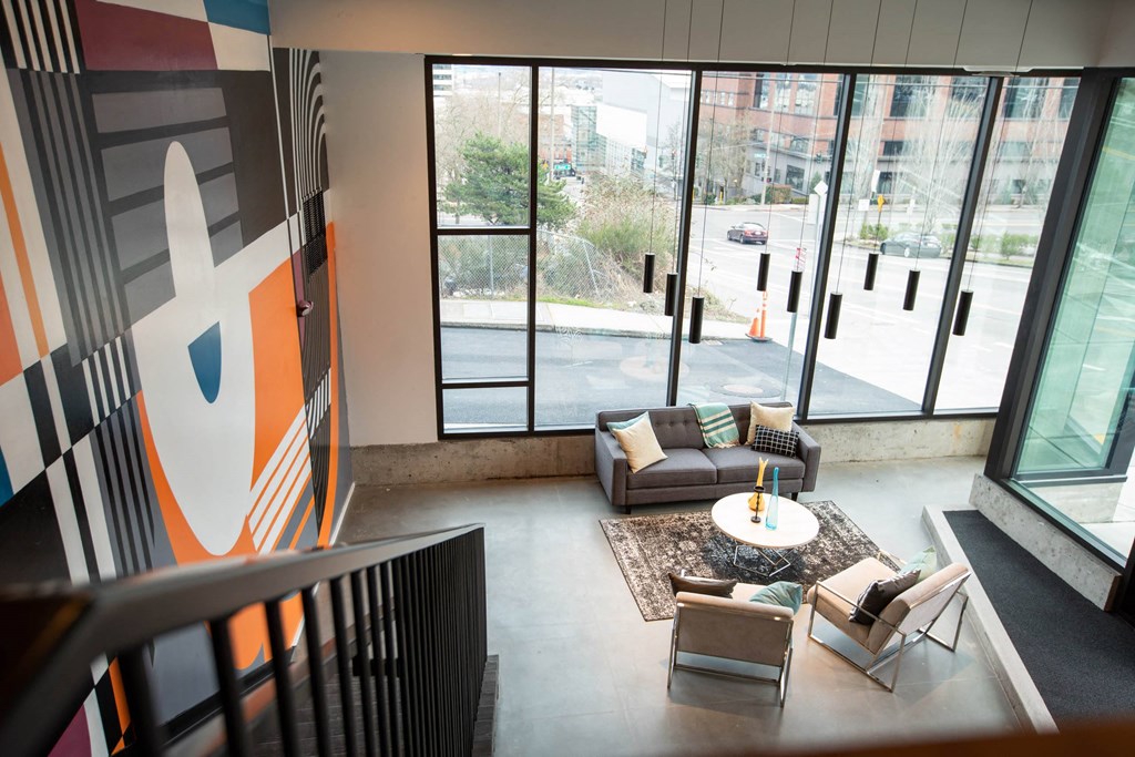 a living room with couches and a table in a building with large windows at Analog Tacoma, Tacoma, WA, 98402