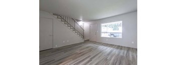 an empty room with a staircase and a large window