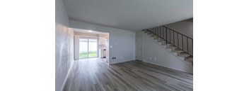 an empty room with a staircase in the background