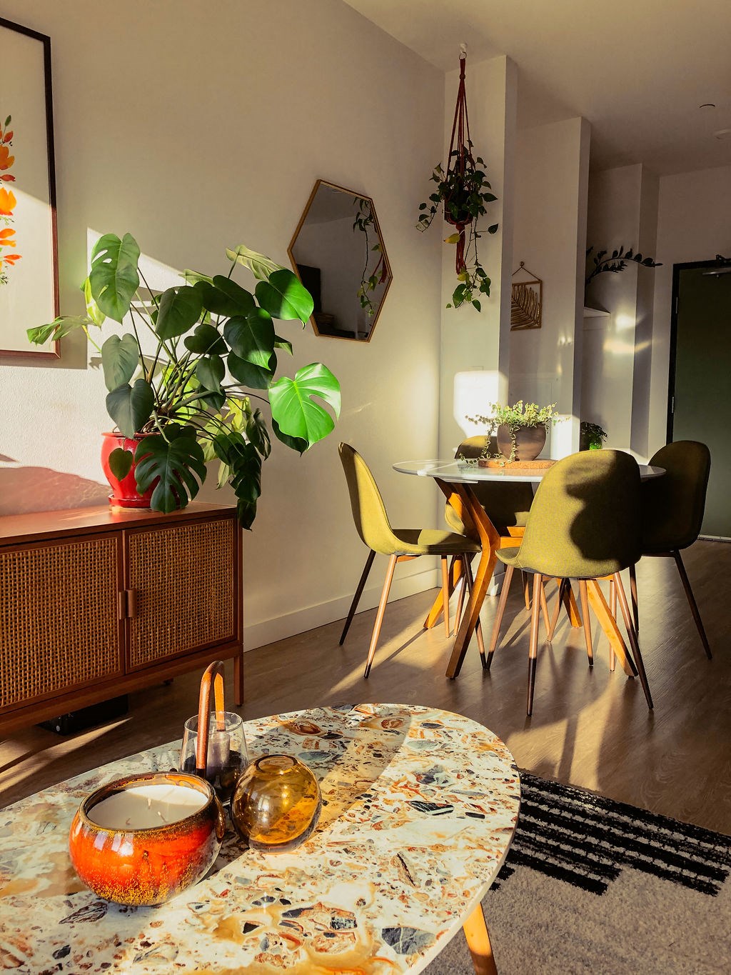 a living room with a table and chairs and a tv hanging on the wall