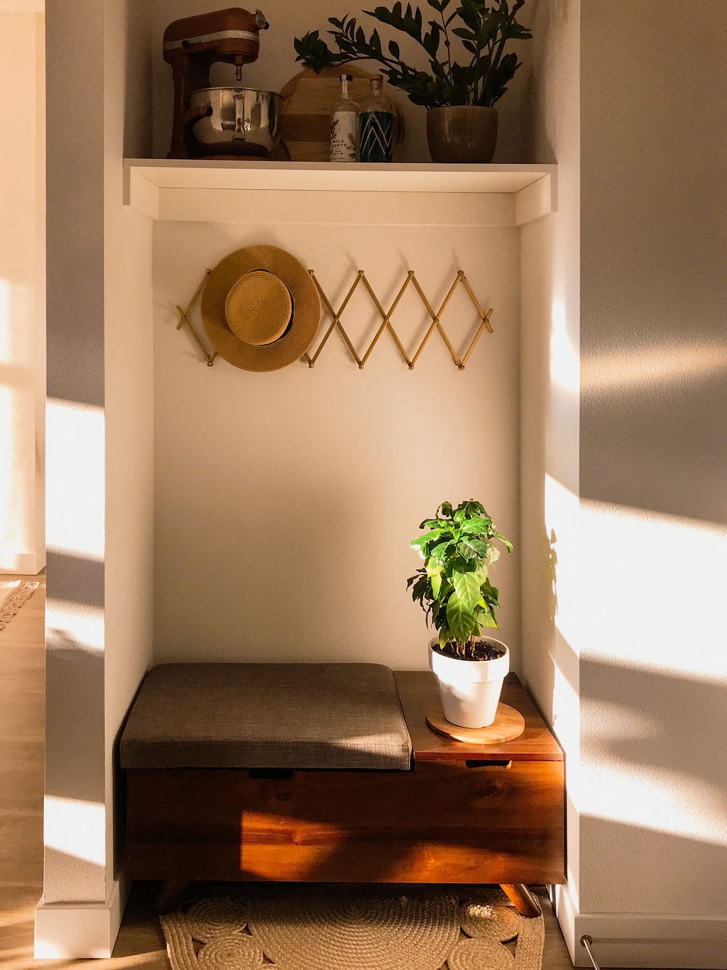 a small nook with a plant and a stool