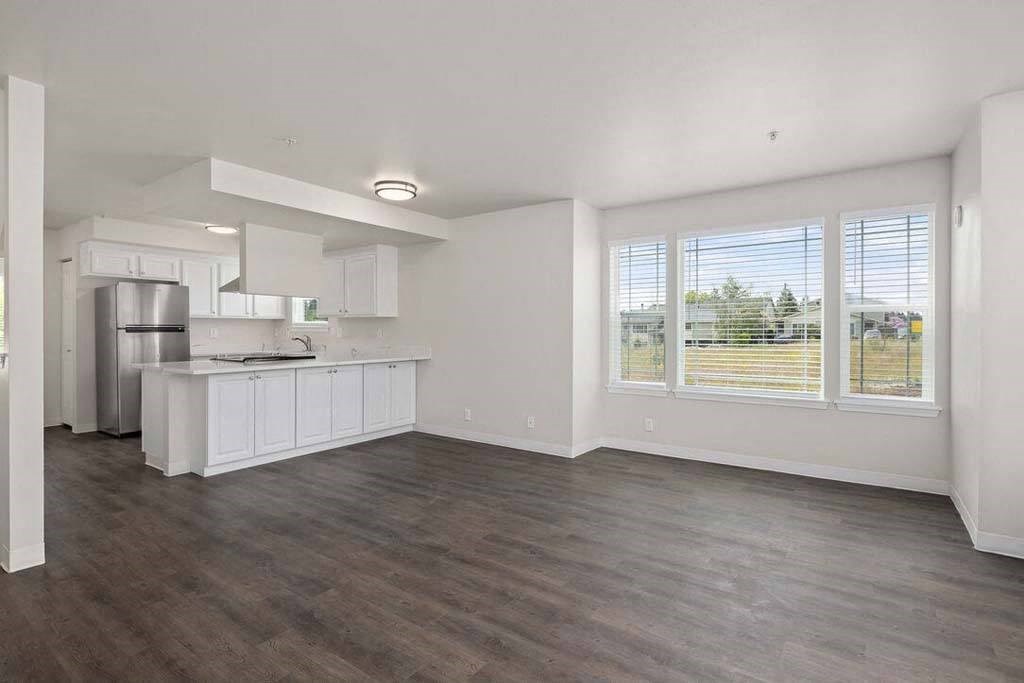an empty kitchen and living room with a large window
