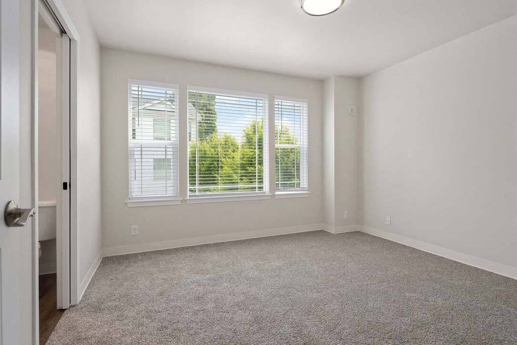 a bedroom with three windows and a door