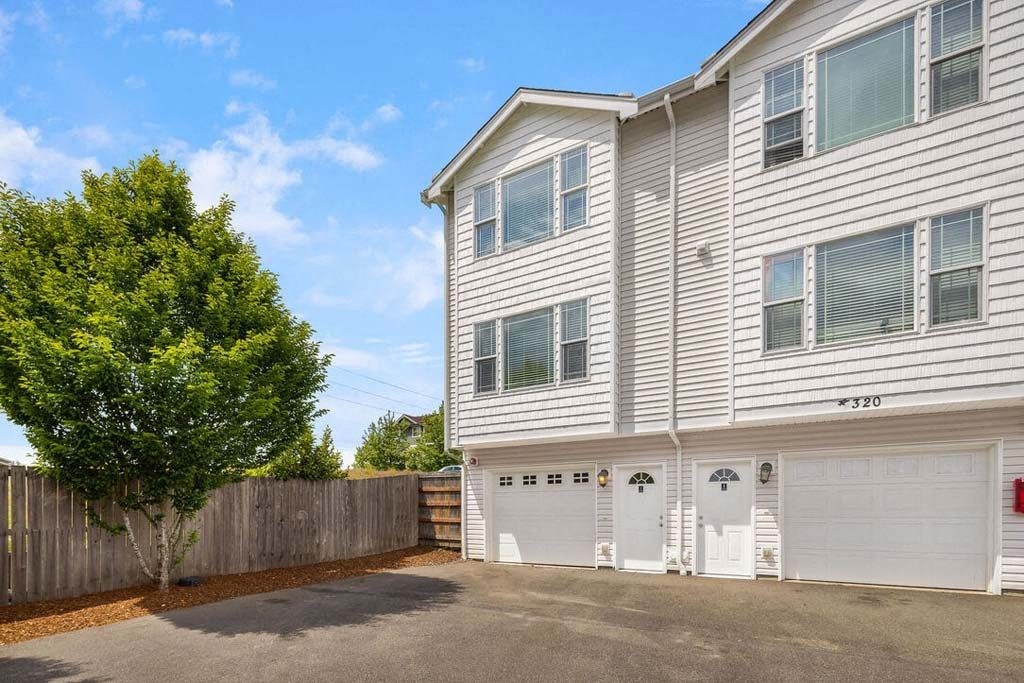 a white house with two garages in front of it