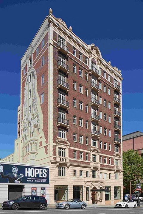 A tall building with a statue on the side and a banner that says "Hopes" on the front.