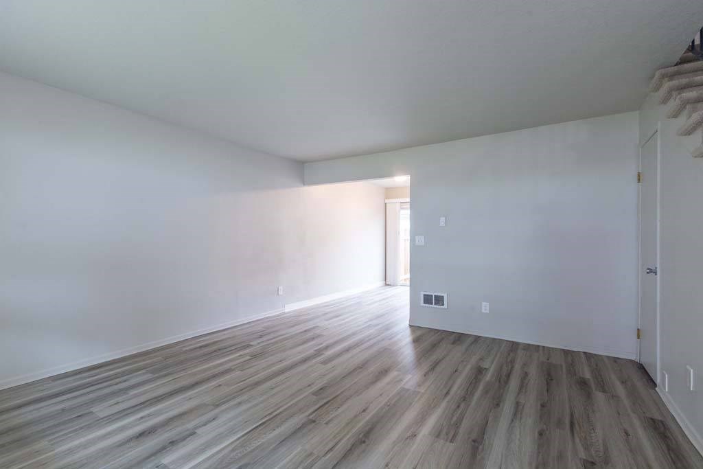 an empty room with white walls and a wooden floor