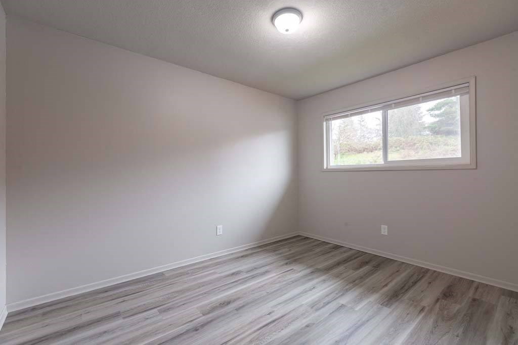 an empty room with a window and a wooden floor