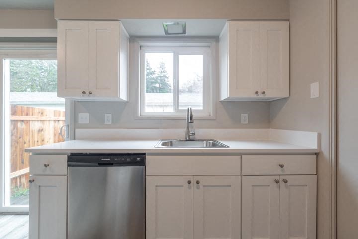 a kitchen with a sink a dishwasher and a window
