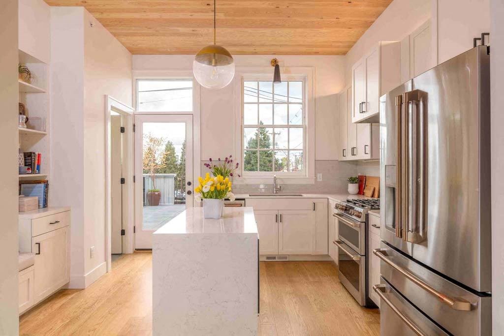 a kitchen with a large center island next to a stove top oven