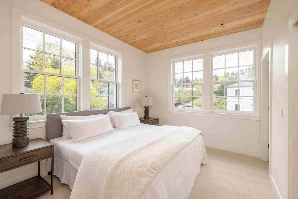 a bedroom with a large bed and a wooden ceiling