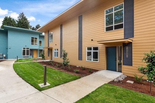 a sidewalk leading up to a building with a blue and yellow building next to it