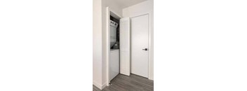 a white kitchen with a white door and a white refrigerator