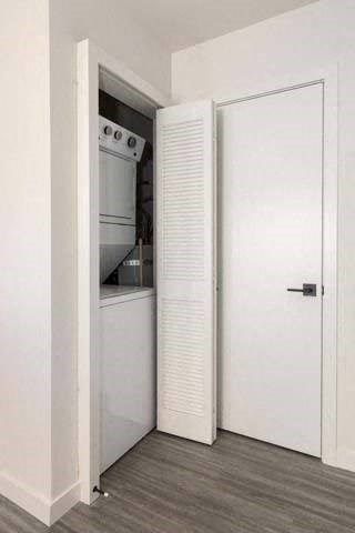a white kitchen with a white door and a white refrigerator