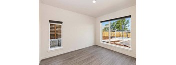 an empty room with a large window and a wooden fence