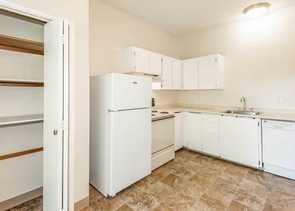 A kitchen with white appliances and cabinets.