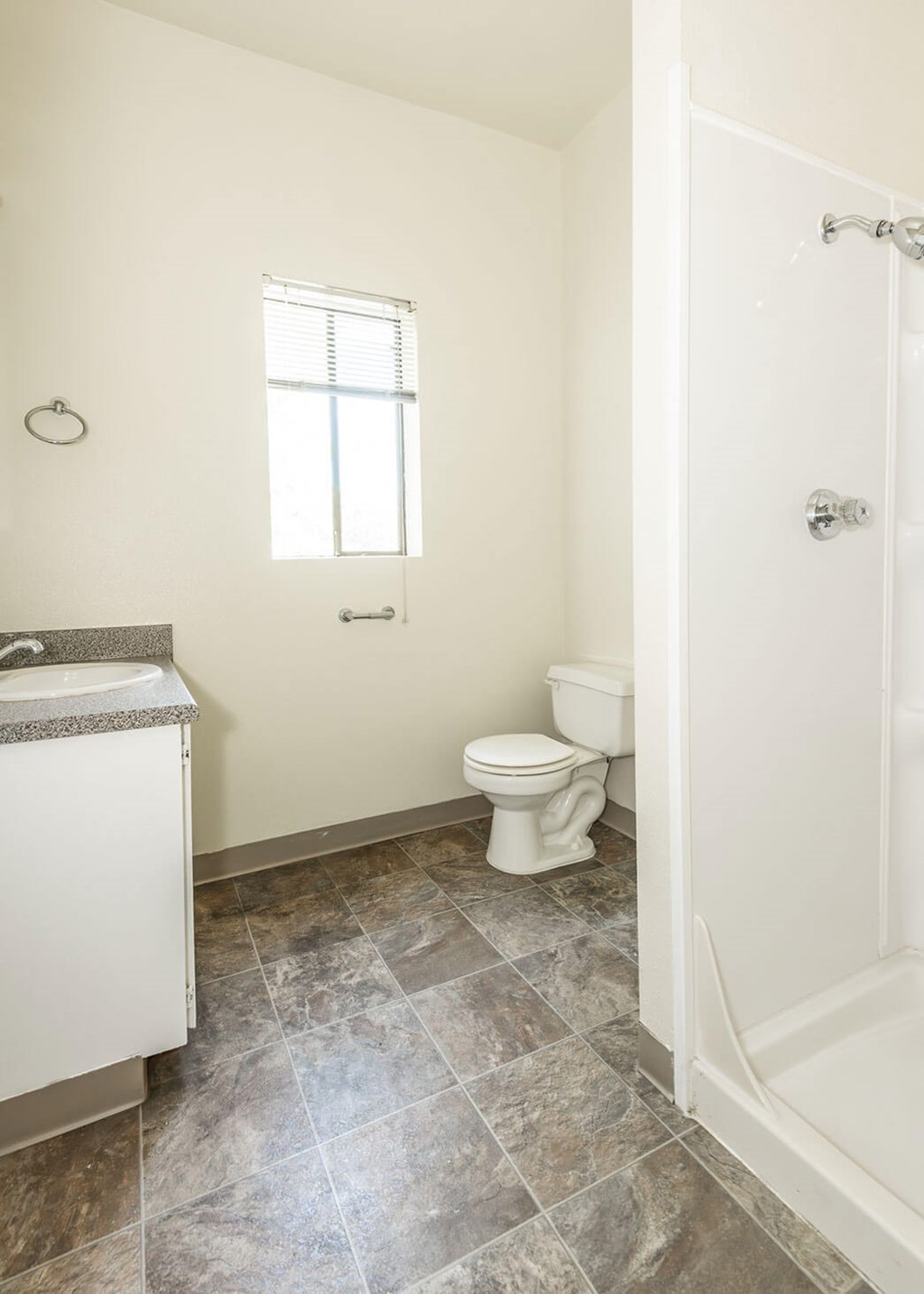 A bathroom with a toilet, sink, and tiled floor.