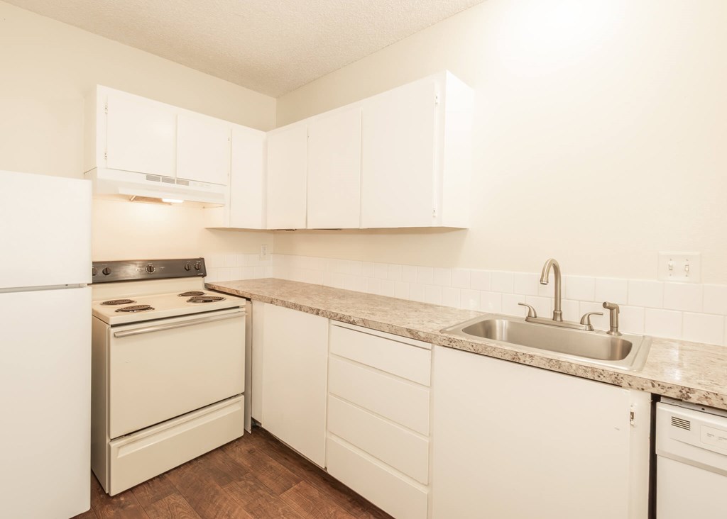A kitchen with white appliances and cabinets.