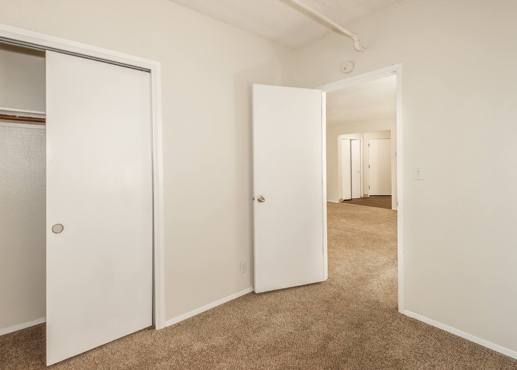 A hallway with two doors on the left and one on the right.