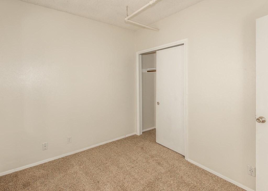 A room with a carpeted floor and a white door.
