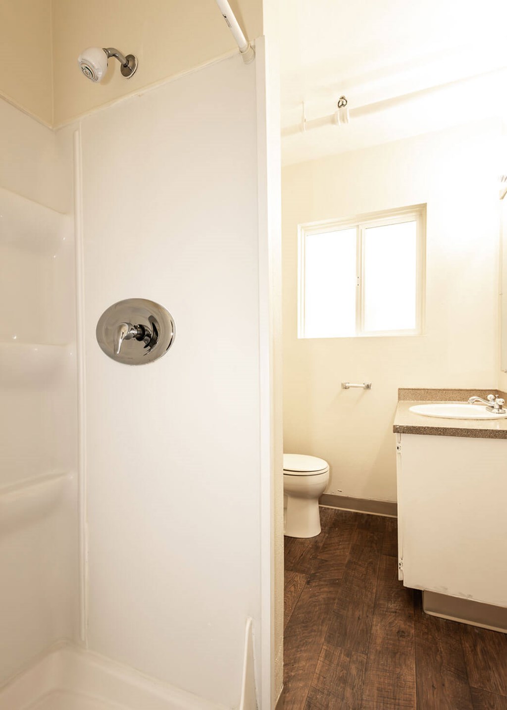 A white bathroom with a toilet, sink, and shower.
