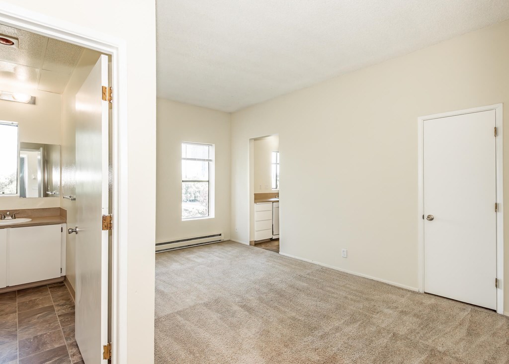 A room with a carpeted floor and a door on the right side.
