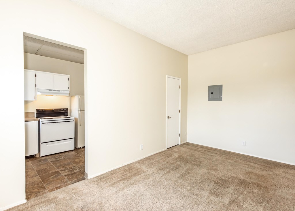 A room with a carpeted floor and a wall-mounted air conditioner unit.