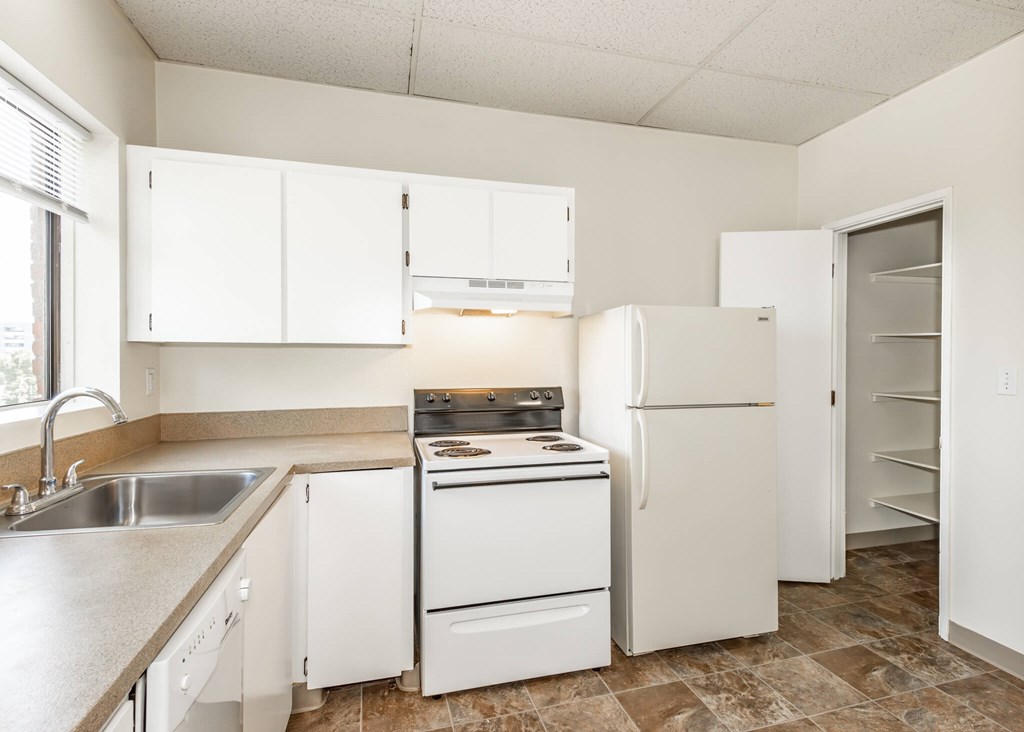 A kitchen with white appliances and cabinets.