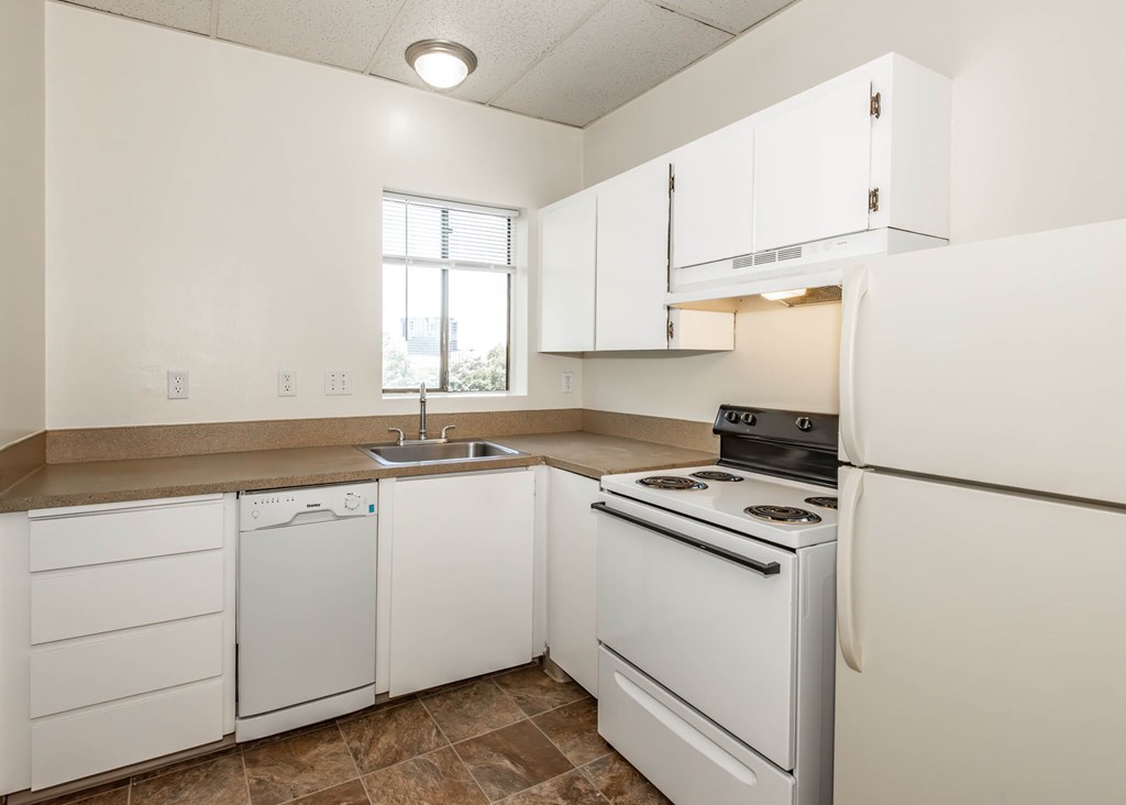 A kitchen with white cabinets and appliances.