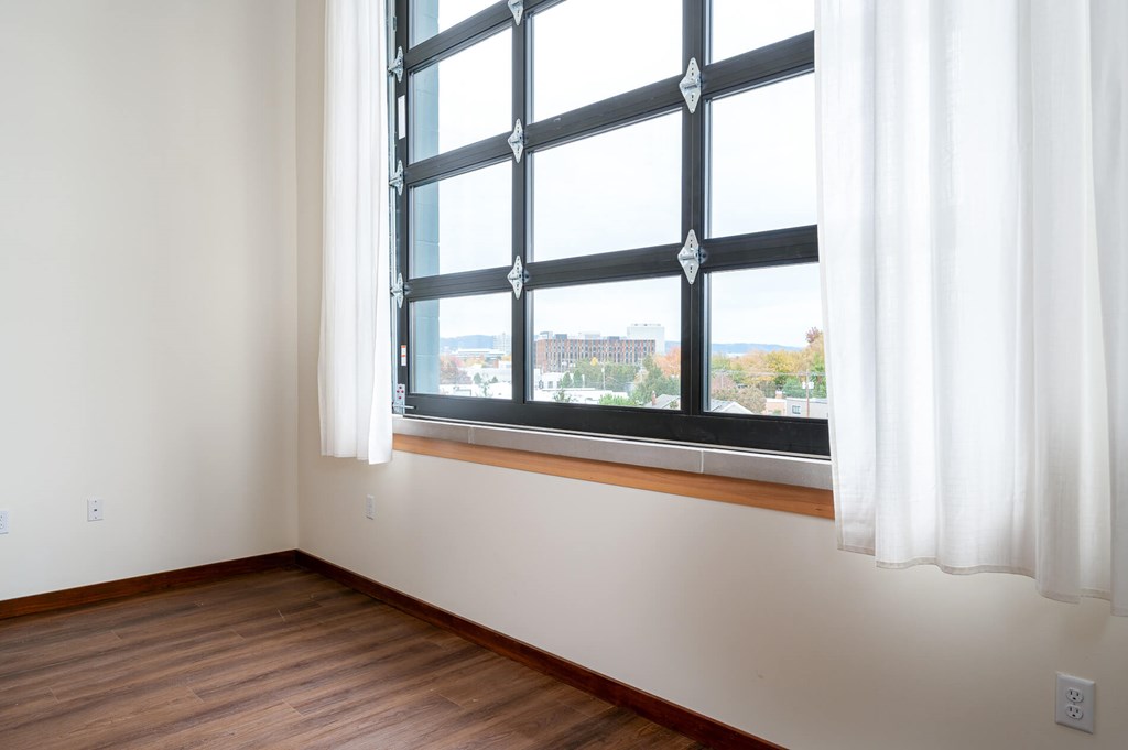 A room with a large window and a view of the city.
