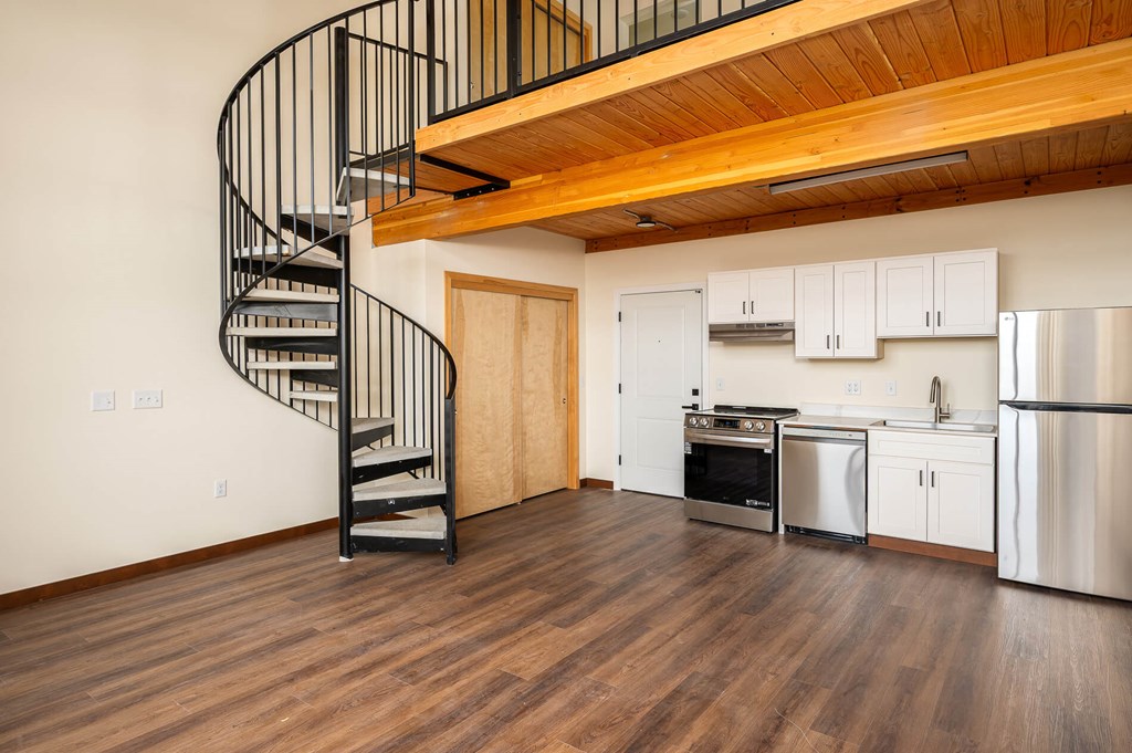 A kitchen with a spiral staircase attached to the wall.