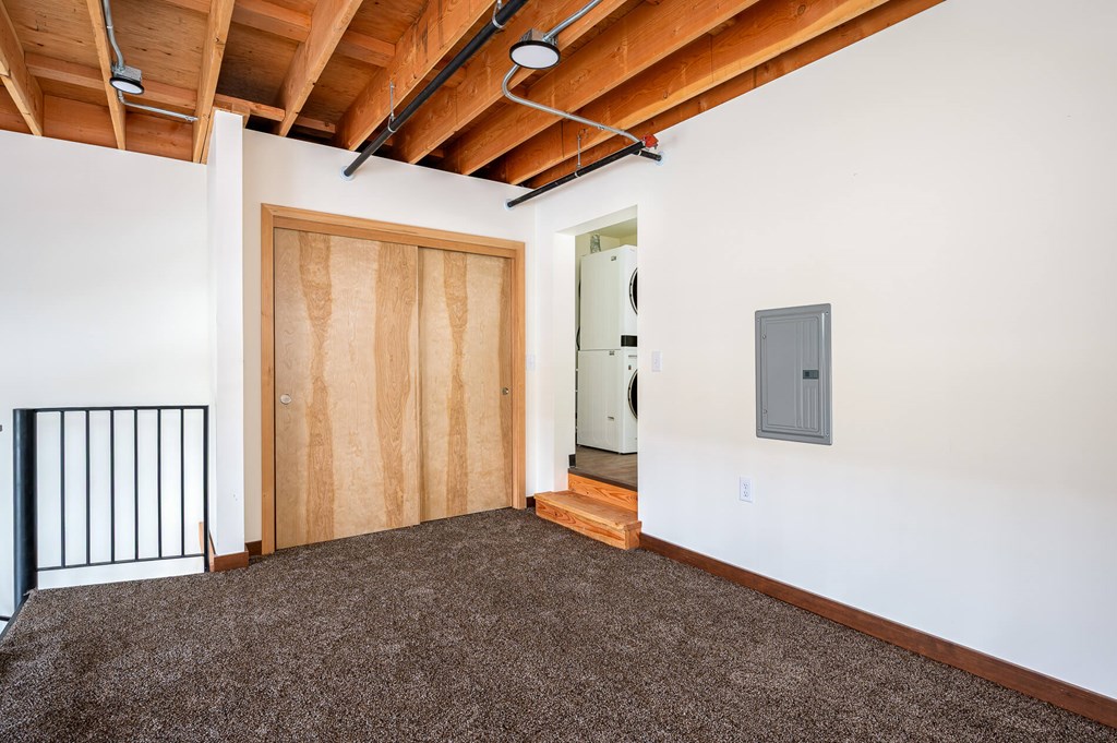 A room with a brown door and a white wall.