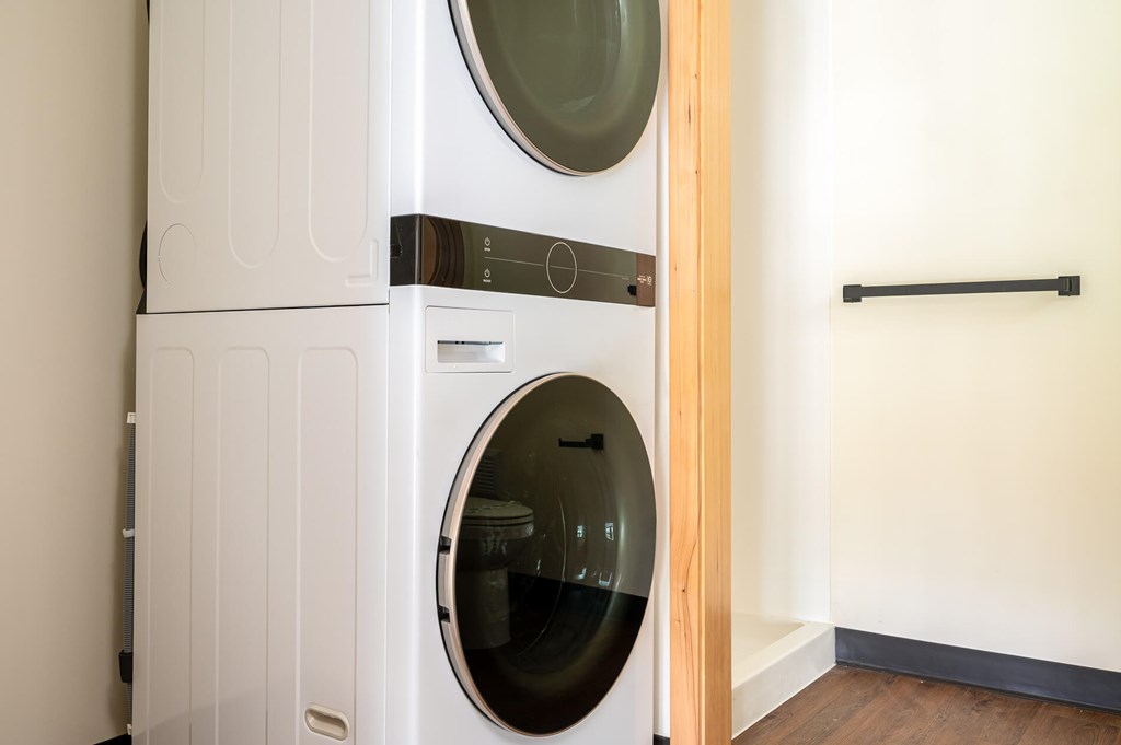 A white front loading washing machine in a laundry room.