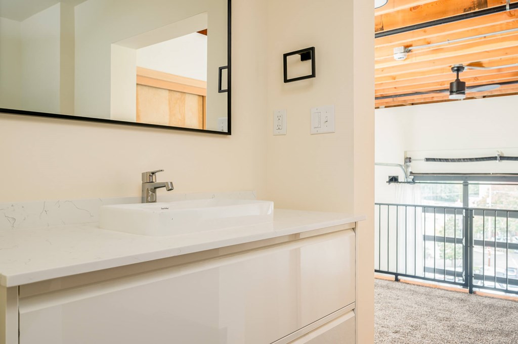 A bathroom with a white sink and a mirror.