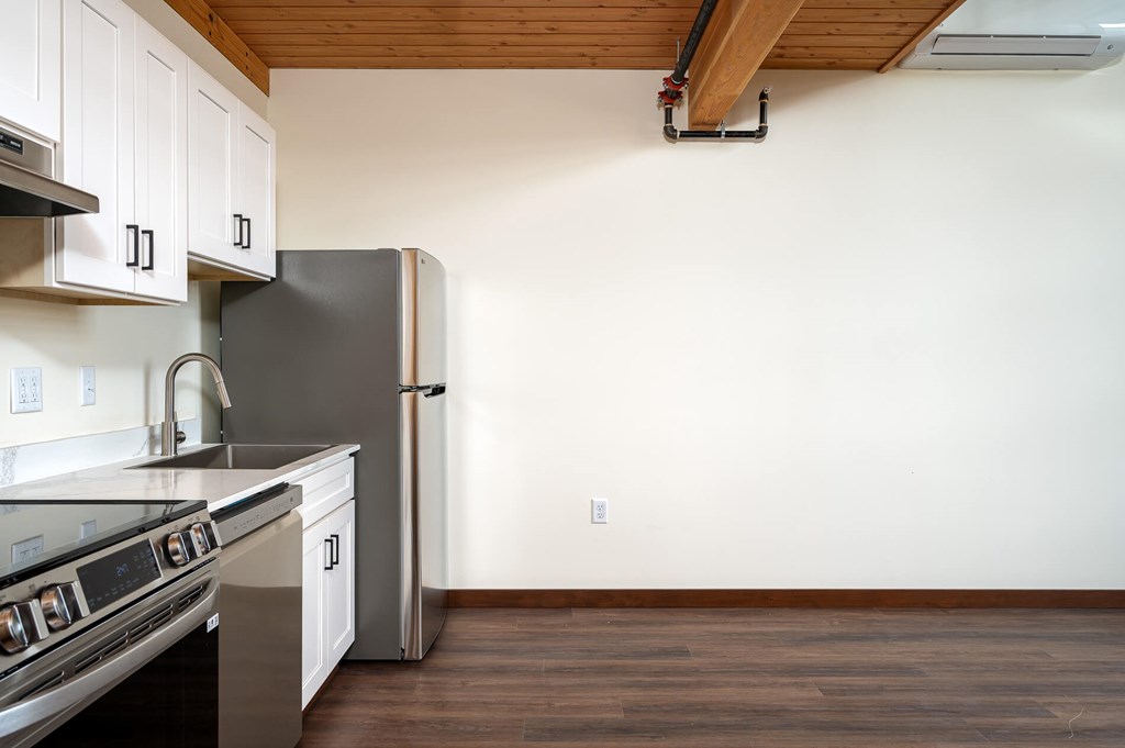 A kitchen with a stove top oven and a refrigerator.