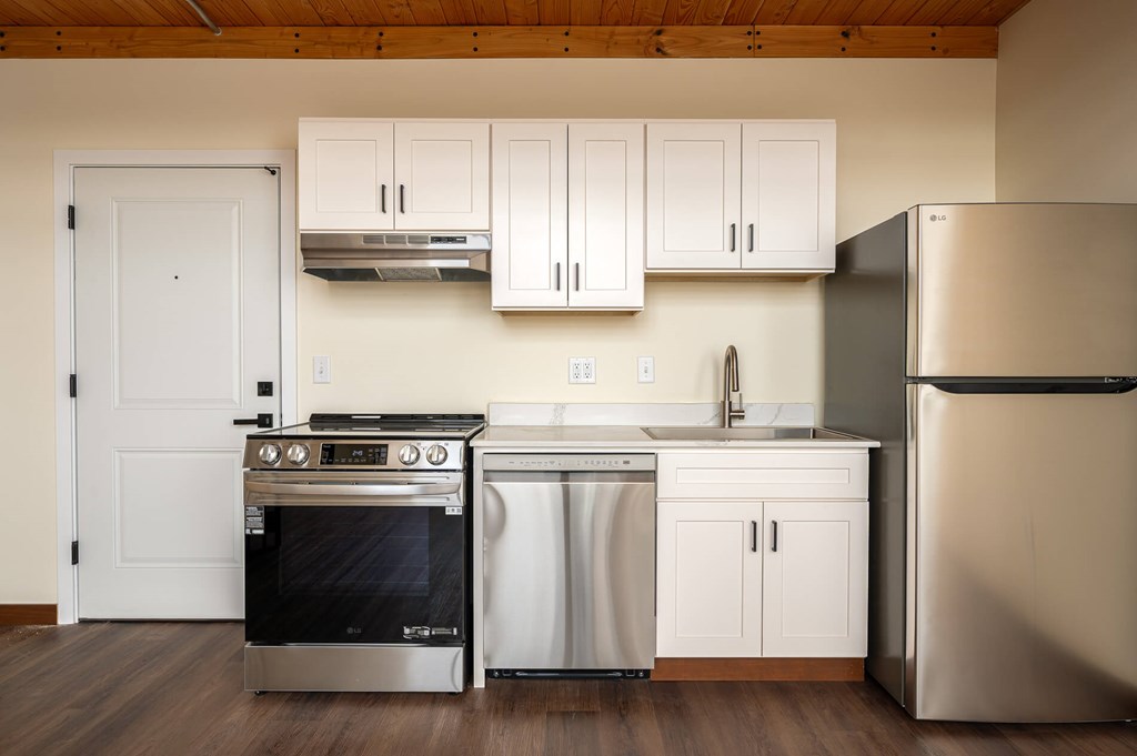 A modern kitchen with white cabinets and stainless steel appliances.