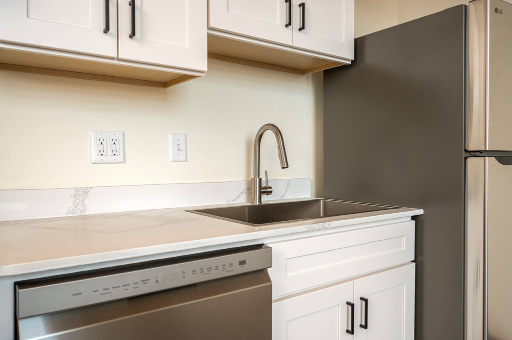 A kitchen with a stainless steel dishwasher and a sink.