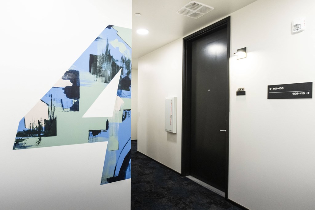 a hallway with a mural on the wall and a black door at Shift, Portland, OR