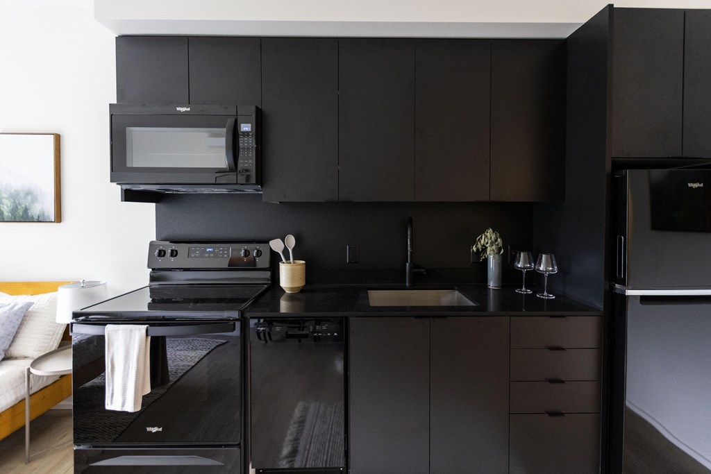 a kitchen with black cabinets and a sink and a microwave at Shift, Oregon, 97217
