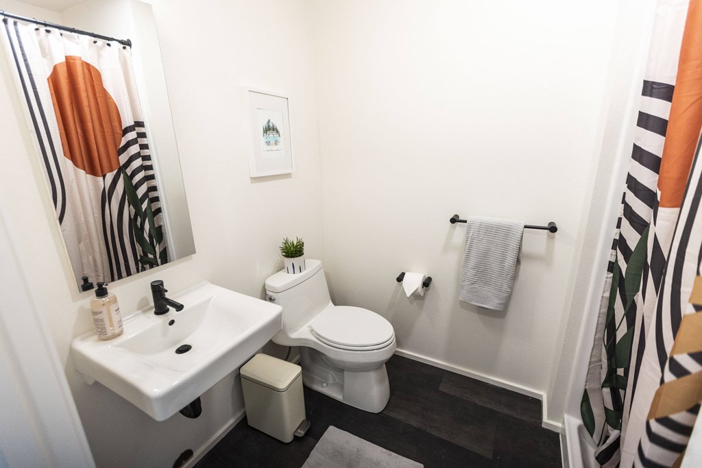 a bathroom with a white toilet and a sink and a shower curtain at Shift, Portland, OR