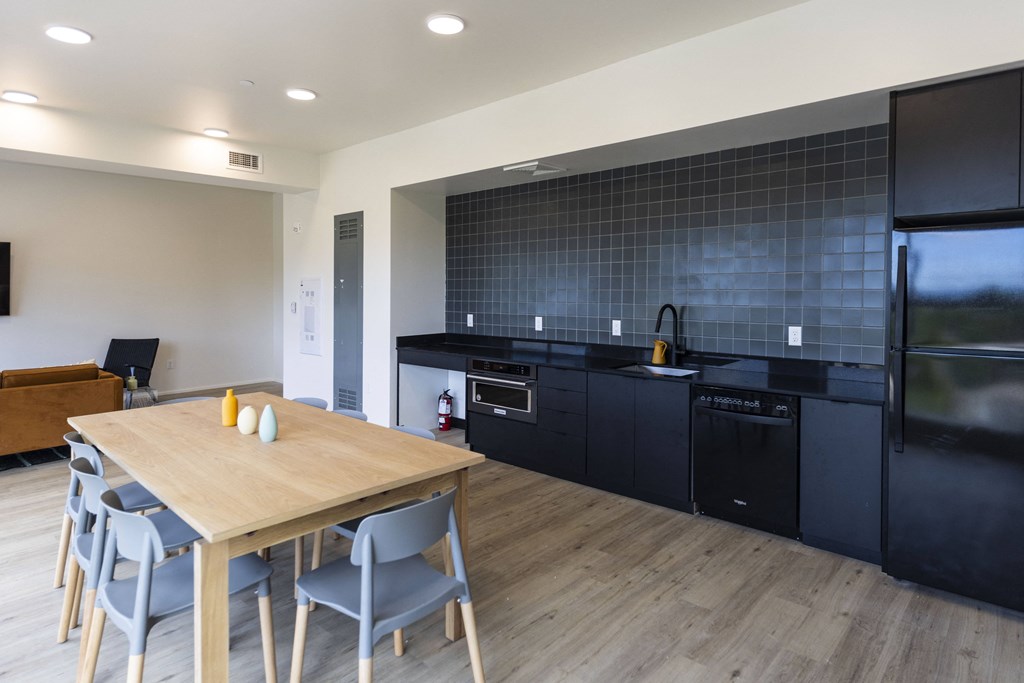 a kitchen and dining room with black appliances and a wooden table at Shift, Portland