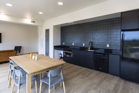 a kitchen and dining room with black appliances and a wooden table